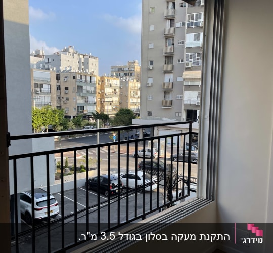 חלון עם מסגרת מתכת ונוף עירוני ברקע